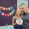 Proud mom with daughter with ceramic happy birthday plate from Polka Dot Pots in Wisconsin Dells